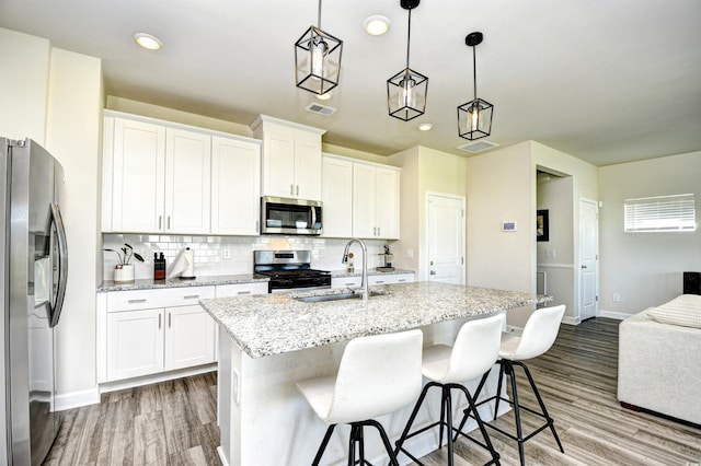 2325 Copper Creek Loop, Longs, SC 29568 - kitchen featuring stainless steel appliances, backsplash, wood finished floors, white cabinetry, and recessed lighting