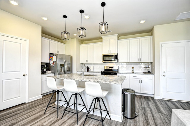 2325 Copper Creek Loop, Longs, SC 29568 - kitchen with stainless steel appliances, dark wood-type flooring, a breakfast bar, backsplash, and a center island with sink