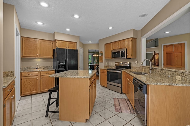 3975 River Hills Dr, Little River, SC 29566 - kitchen featuring appliances with stainless steel finishes, light stone countertops, a kitchen island, a breakfast bar area, and light tile patterned floors