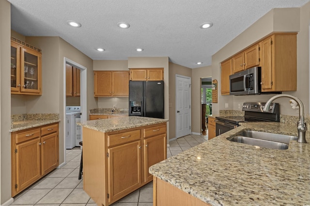 3975 River Hills Dr, Little River, SC 29566 - kitchen featuring appliances with stainless steel finishes, light stone counters, independent washer and dryer, light tile patterned flooring, and recessed lighting