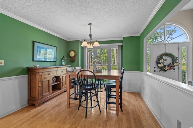 3975 River Hills Dr, Little River, SC 29566 - dining area with a textured ceiling, a chandelier, light wood-style floors, wainscoting, and crown molding