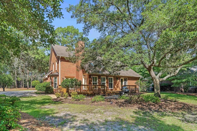 3975 River Hills Dr, Little River, SC 29566 - view of front of property featuring a deck, a chimney, a front yard, and brick siding