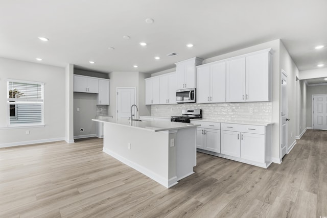 4881 Hopespring St, Myrtle Beach, SC 29579 - kitchen with stainless steel appliances, decorative backsplash, an island with sink, white cabinetry, and recessed lighting