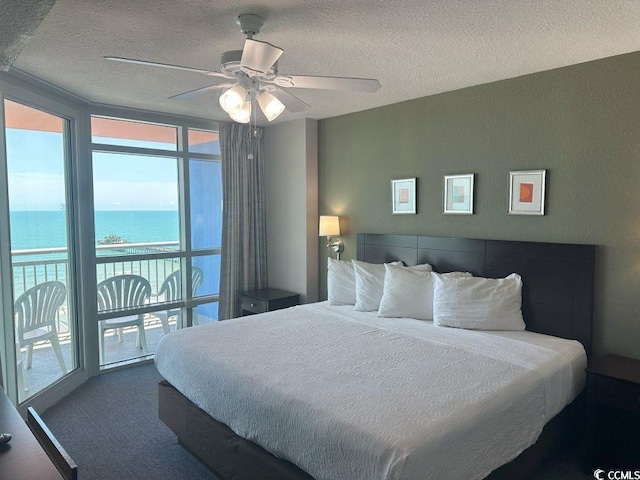 3601 N Ocean Blvd Unit 1139, North Myrtle Beach, SC 29582 - bedroom with a textured ceiling, a water view, access to exterior, ceiling fan, and floor to ceiling windows