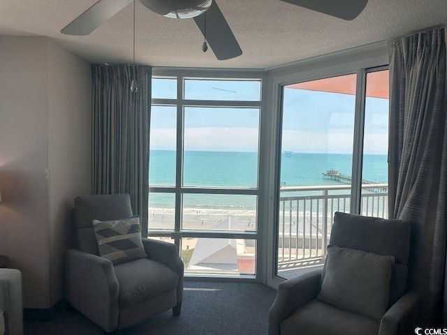3601 N Ocean Blvd Unit 1139, North Myrtle Beach, SC 29582 - sitting room featuring ceiling fan, a water view, plenty of natural light, a textured ceiling, and carpet floors
