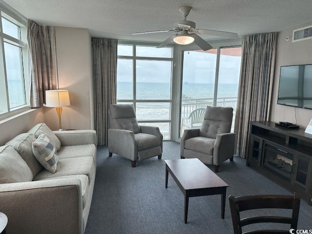 3601 N Ocean Blvd Unit 1139, North Myrtle Beach, SC 29582 - living room with expansive windows, carpet flooring, a textured ceiling, and a ceiling fan