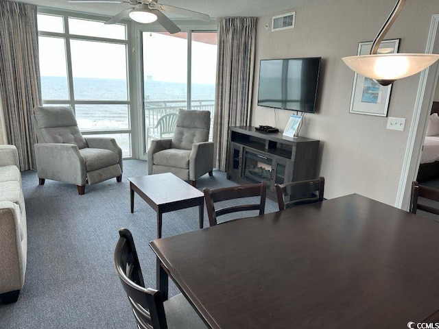 3601 N Ocean Blvd Unit 1139, North Myrtle Beach, SC 29582 - living area with a wall of windows, ceiling fan, healthy amount of natural light, and carpet