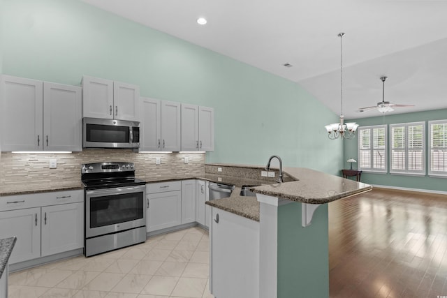 156 Parmelee Dr Unit D, Murrells Inlet, SC 29576 - kitchen with appliances with stainless steel finishes, lofted ceiling, a peninsula, a breakfast bar, and tasteful backsplash