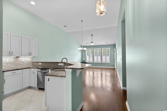 156 Parmelee Dr Unit D, Murrells Inlet, SC 29576 - kitchen with stainless steel dishwasher, a peninsula, lofted ceiling, dark stone countertops, and a chandelier