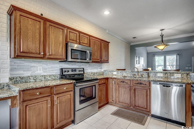 100 Culpepper Way Unit 1002, Myrtle Beach, SC 29579 - kitchen with stainless steel appliances, a peninsula, brown cabinets, light tile patterned flooring, and ornamental molding