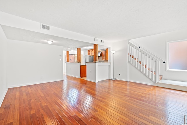 310 74th Ave N Unit 7, Myrtle Beach, SC 29572 - unfurnished living room featuring stairs, light wood-style flooring, and a textured ceiling