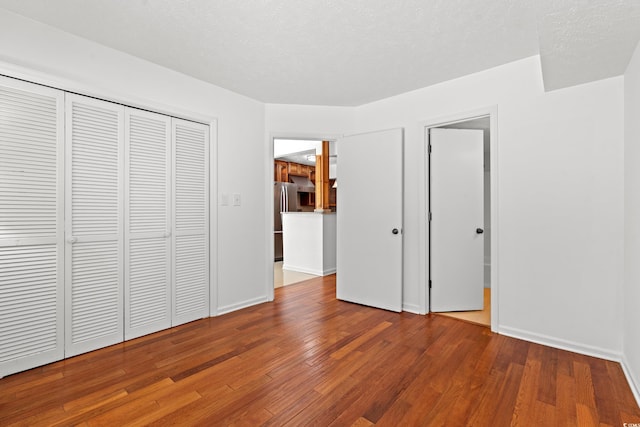 310 74th Ave N Unit 7, Myrtle Beach, SC 29572 - unfurnished bedroom featuring wood finished floors, freestanding refrigerator, and a closet
