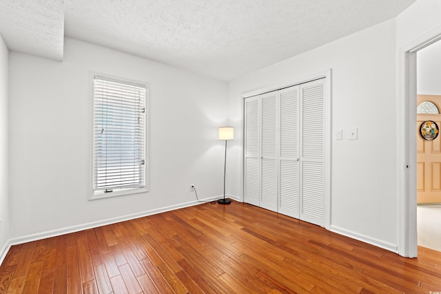 310 74th Ave N Unit 7, Myrtle Beach, SC 29572 - unfurnished bedroom with a textured ceiling, a closet, and wood-type flooring