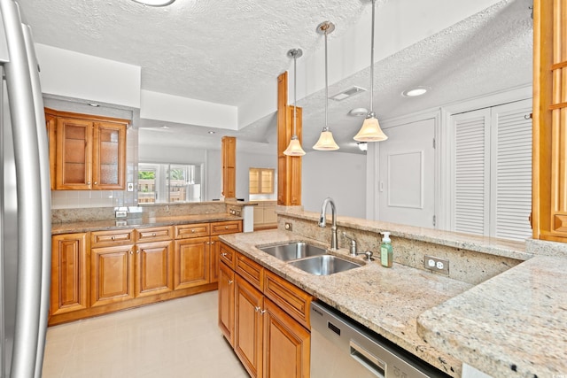 310 74th Ave N Unit 7, Myrtle Beach, SC 29572 - kitchen with a textured ceiling, stainless steel dishwasher, light stone counters, brown cabinetry, and decorative light fixtures