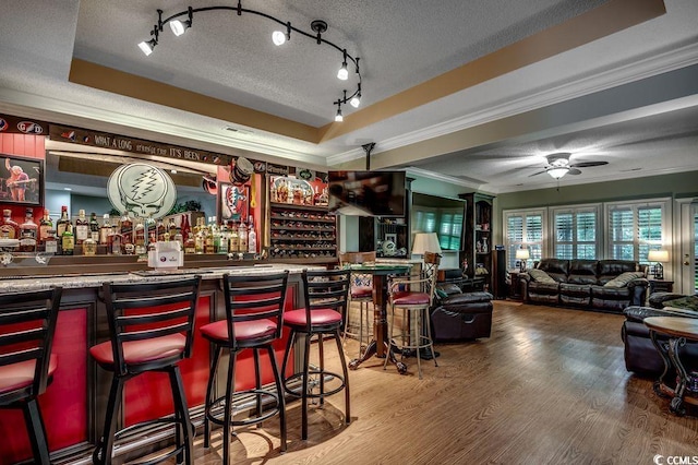 2450 Marsh Glen Dr Unit 112, North Myrtle Beach, SC 29582 - indoor dry bar featuring ornamental molding, a raised ceiling, wood finished floors, a textured ceiling, and ceiling fan