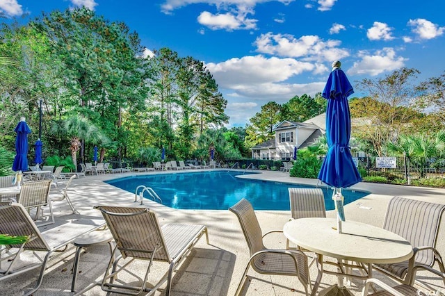 2450 Marsh Glen Dr Unit 112, North Myrtle Beach, SC 29582 - community pool featuring a patio and view of wooded area