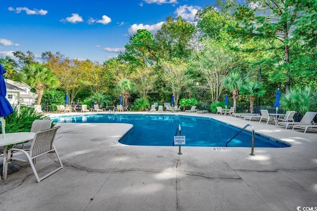 2450 Marsh Glen Dr Unit 112, North Myrtle Beach, SC 29582 - community pool featuring a patio and view of scattered trees