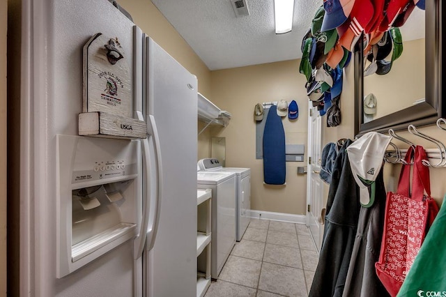 2450 Marsh Glen Dr Unit 112, North Myrtle Beach, SC 29582 - laundry area with washer and clothes dryer, light tile patterned flooring, and a textured ceiling