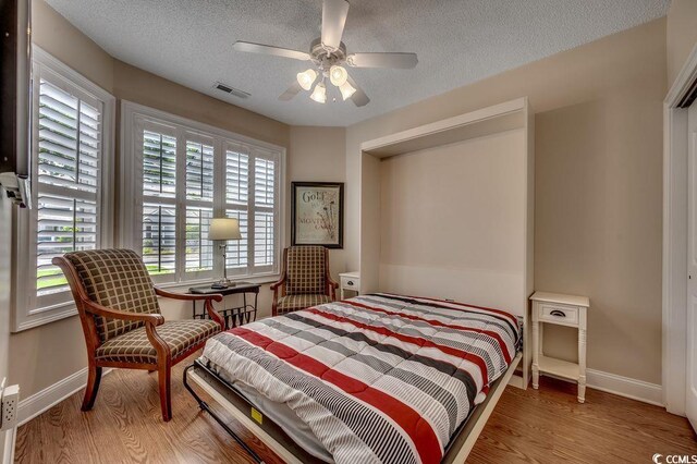 2450 Marsh Glen Dr Unit 112, North Myrtle Beach, SC 29582 - bedroom with wood finished floors, a textured ceiling, and ceiling fan