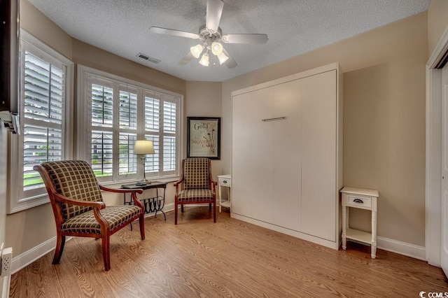 2450 Marsh Glen Dr Unit 112, North Myrtle Beach, SC 29582 - living area featuring wood finished floors, a ceiling fan, and a textured ceiling