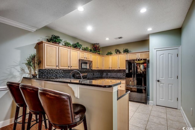 2450 Marsh Glen Dr Unit 112, North Myrtle Beach, SC 29582 - kitchen with black appliances, a peninsula, tasteful backsplash, light brown cabinets, and recessed lighting
