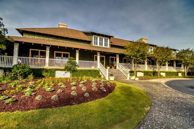 2450 Marsh Glen Dr Unit 112, North Myrtle Beach, SC 29582 - view of front of home with covered porch, a chimney, and stairs