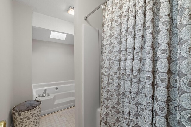 311 Ashwood Ln, Myrtle Beach, SC 29588 - bathroom featuring a skylight, a bath, tile patterned floors, and a shower with curtain