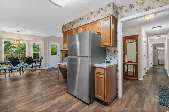 311 Ashwood Ln, Myrtle Beach, SC 29588 - kitchen featuring freestanding refrigerator, light countertops, dark wood-style flooring, pendant lighting, and brown cabinets