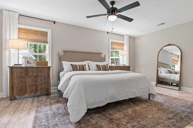 589 Boundaryline Dr NW, Calabash, NC 28467 - bedroom with wood finished floors, multiple windows, and a ceiling fan