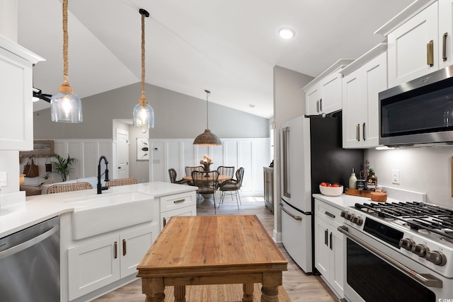 589 Boundaryline Dr NW, Calabash, NC 28467 - kitchen featuring stainless steel appliances, light countertops, white cabinets, light wood-type flooring, and lofted ceiling