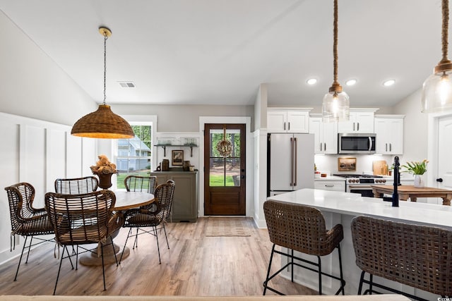589 Boundaryline Dr NW, Calabash, NC 28467 - kitchen featuring stainless steel appliances, light countertops, white cabinets, light wood-style flooring, and pendant lighting
