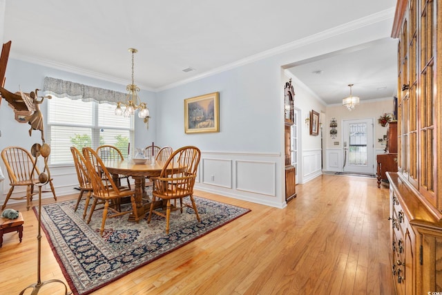 138 Copper Leaf Dr, Myrtle Beach, SC 29588 - dining area featuring a chandelier, plenty of natural light, light wood-style flooring, a wainscoted wall, and crown molding