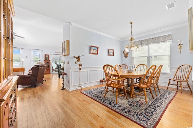 138 Copper Leaf Dr, Myrtle Beach, SC 29588 - dining space with light wood-style flooring, a chandelier, ornamental molding, wainscoting, and a decorative wall