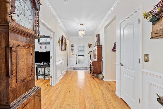 138 Copper Leaf Dr, Myrtle Beach, SC 29588 - foyer entrance featuring light wood-style flooring, ornamental molding, a decorative wall, a wainscoted wall, and a chandelier