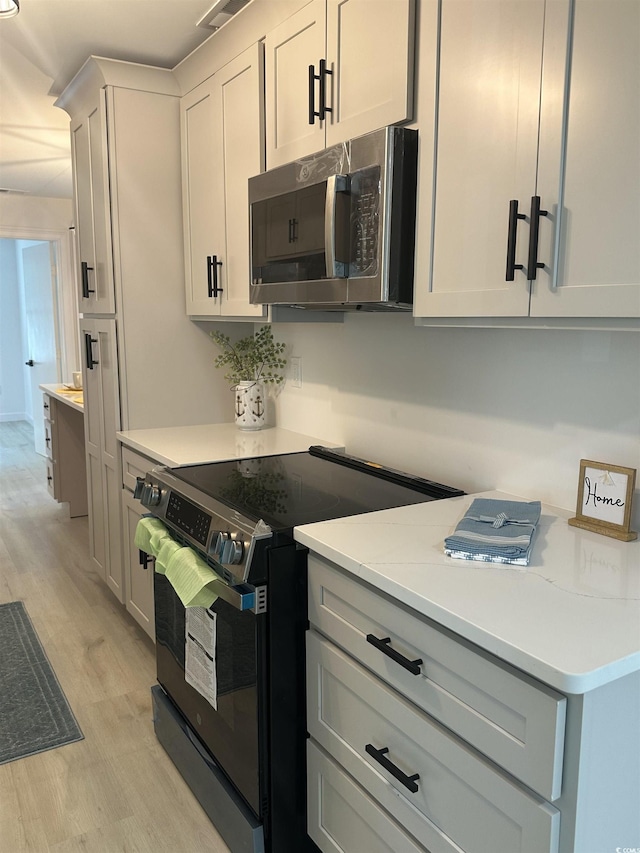 518 Nowell St, Georgetown, SC 29440 - kitchen with stainless steel microwave, electric range oven, light wood-style floors, and light countertops