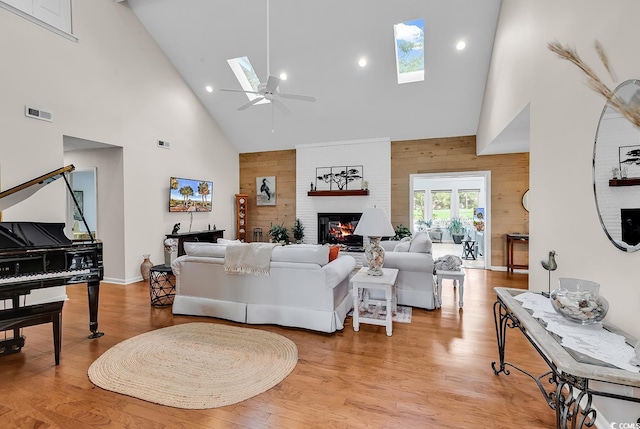 1064 Links Rd, Surfside Beach, SC 29575 - living room with high vaulted ceiling, a skylight, a ceiling fan, wooden walls, and a fireplace