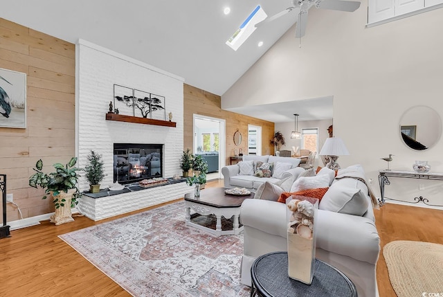 1064 Links Rd, Surfside Beach, SC 29575 - living room featuring high vaulted ceiling, ceiling fan, wood walls, wood finished floors, and a brick fireplace
