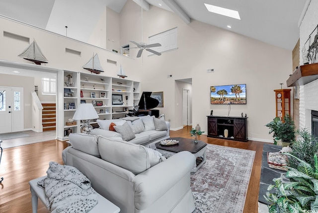 1064 Links Rd, Surfside Beach, SC 29575 - living area featuring a skylight, stairway, beamed ceiling, high vaulted ceiling, and a fireplace