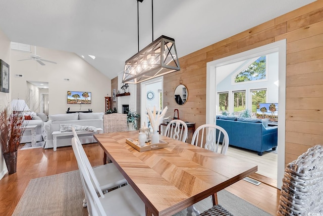 1064 Links Rd, Surfside Beach, SC 29575 - dining room featuring wooden walls, a ceiling fan, wood finished floors, and high vaulted ceiling