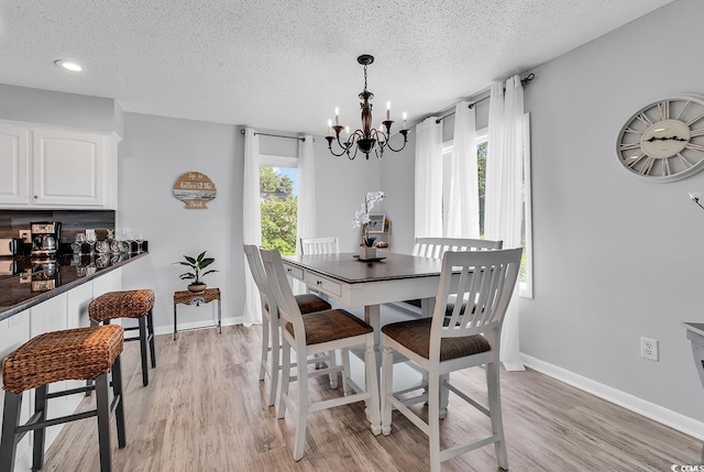 1064 Links Rd, Surfside Beach, SC 29575 - dining space featuring a chandelier, light wood-style floors, and a textured ceiling