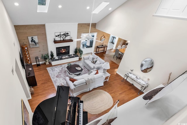1064 Links Rd, Surfside Beach, SC 29575 - living area featuring a skylight, wood walls, wood finished floors, a large fireplace, and recessed lighting