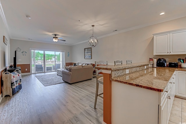 110 S Shore Blvd Unit 203, Longs, SC 29568 - living room featuring a ceiling fan, light wood-style floors, ornamental molding, recessed lighting, and a chandelier