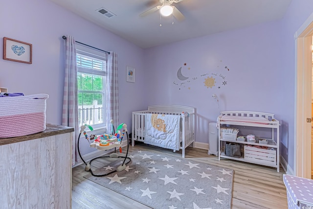 110 S Shore Blvd Unit 203, Longs, SC 29568 - bedroom with wood finished floors, a nursery area, and a ceiling fan