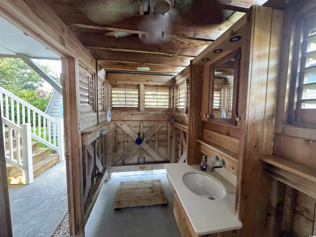 404 29th Ave N, North Myrtle Beach, SC 29582 - bathroom featuring plenty of natural light, wood walls, vanity, and concrete floors