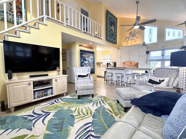 404 29th Ave N, North Myrtle Beach, SC 29582 - living room with a ceiling fan, a towering ceiling, and light wood-type flooring