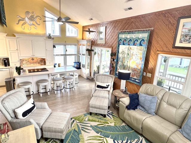 404 29th Ave N, North Myrtle Beach, SC 29582 - living area with a ceiling fan, wood walls, light wood-type flooring, and high vaulted ceiling