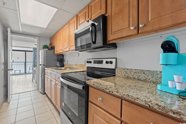 1501 S Ocean Blvd Unit 1039, Myrtle Beach, SC 29577 - kitchen with stainless steel range with electric cooktop, black microwave, light tile patterned floors, light stone counters, and a paneled ceiling