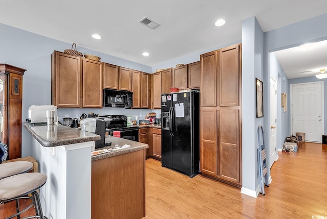 1857 Culbertson Ave Unit 1857, Myrtle Beach, SC 29577 - kitchen with black appliances, a peninsula, light wood-style floors, brown cabinets, and recessed lighting