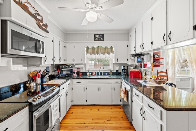 1005 S Main St, Mullins, SC 29574 - kitchen featuring appliances with stainless steel finishes, crown molding, white cabinetry, a textured ceiling, and a peninsula