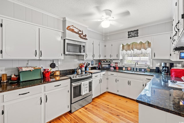 1005 S Main St, Mullins, SC 29574 - kitchen featuring appliances with stainless steel finishes, crown molding, white cabinetry, a textured ceiling, and a ceiling fan